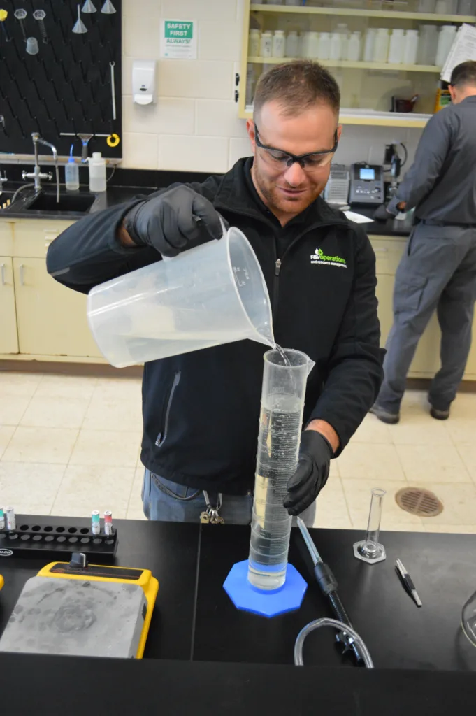 FVOP Team Member Pouring Water Into Graduated Cylinder